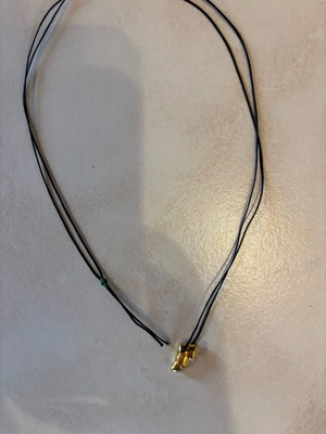 Gold necklace new with small paw on black cord