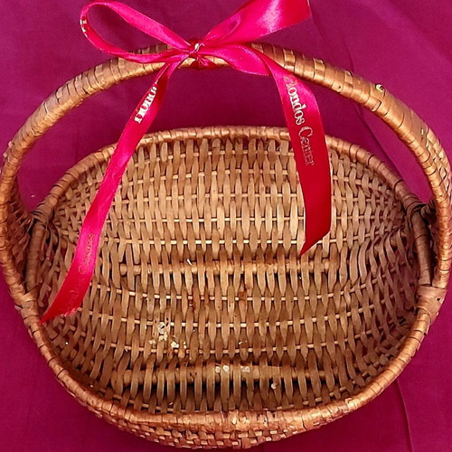 Woven straw basket used with red satin ribbon