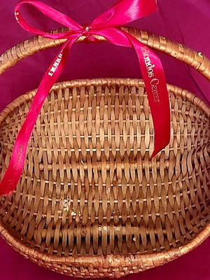 Woven straw basket used with red satin ribbon