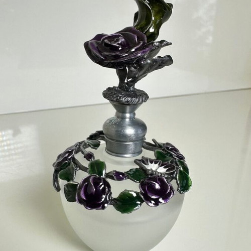Vintage ornate perfume bottle with frosted glass and metal floral decoration