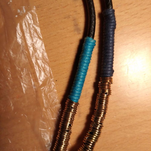 Necklace new rubber with wrapped threads and gold and silver rings