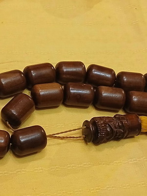 Wooden komboloi used with carved priest figure
