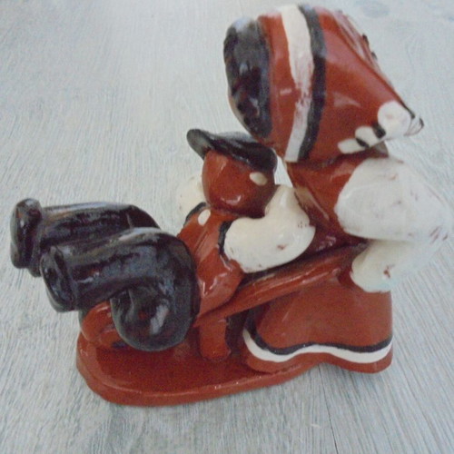Ceramic figure used, retro genre scene woman pushing man in cart