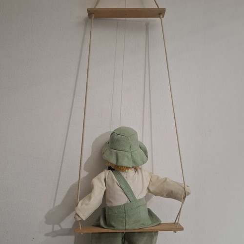Porcelain clown doll on wooden swing, vintage collectible