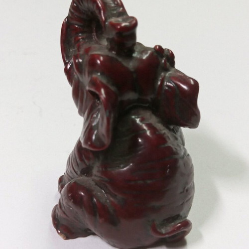 Carved miniature laughing elephant statue like new, burgundy color