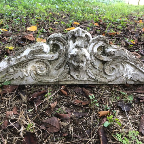Old plaster pediment used with spiral motifs and human head