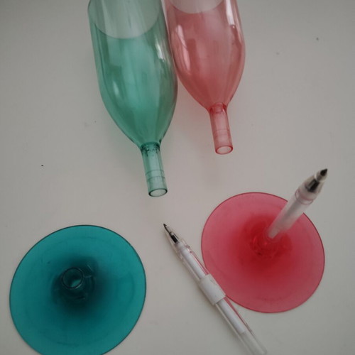 Plastic champagne glasses used, pink and green with hidden pen
