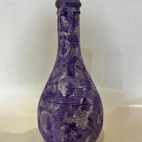 Vintage decorative glass vase covered with lilac rope, used