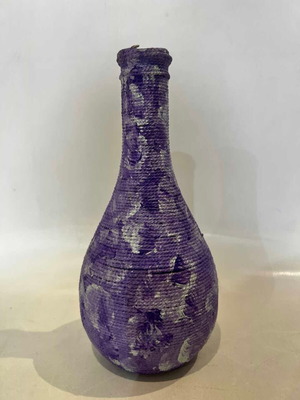 Vintage decorative glass vase covered with lilac rope, used