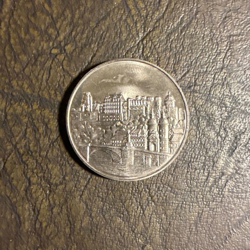 Collectible metal coin with embossed castle design, new