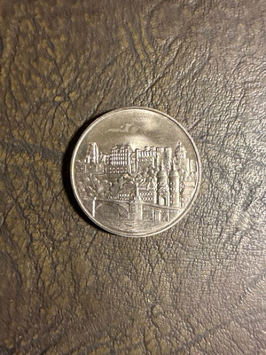 Collectible metal coin with embossed castle design, new