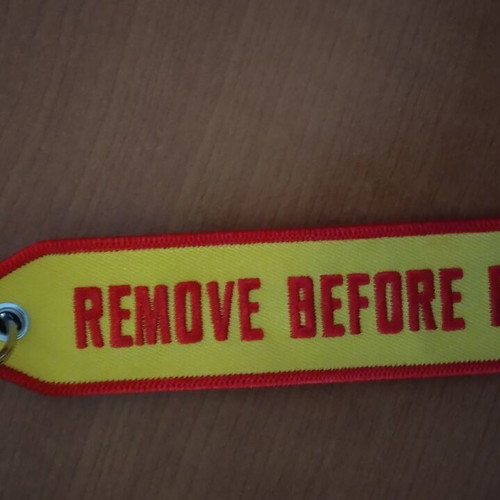 Remove Before Flight fabric keychain in excellent condition