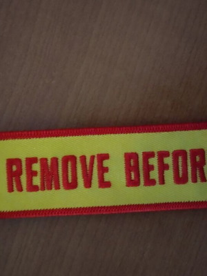 Remove Before Flight fabric keychain in excellent condition