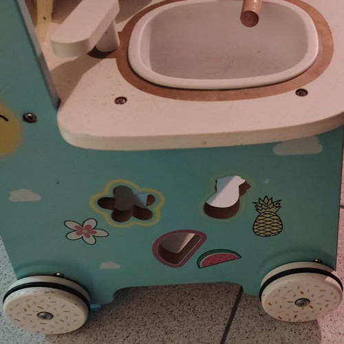 Wooden play kitchen with oven used, with pots and spoons
