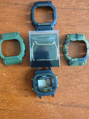 Casio G-Shock DW 5600 original θήκη και 3 εξωτερικές ελαστικές προστατευτικές με χρυσό Bullbar καινούργιο
