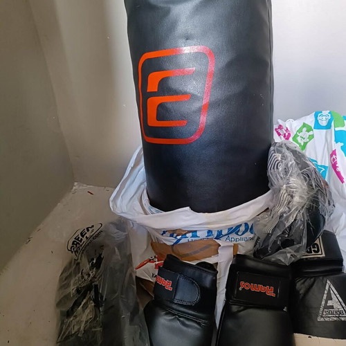 Boxing bag with gloves, hand wraps and knee pads used
