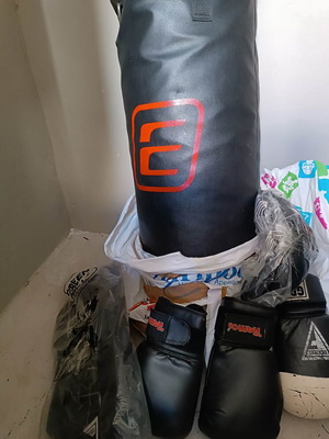 Boxing bag with gloves, hand wraps and knee pads used