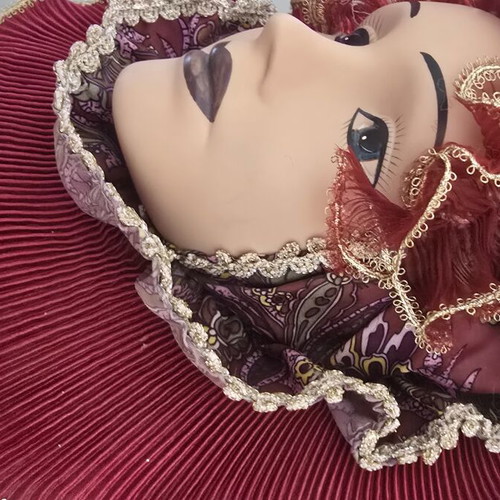 Decorative porcelain wall mask used with fabric hat in burgundy
