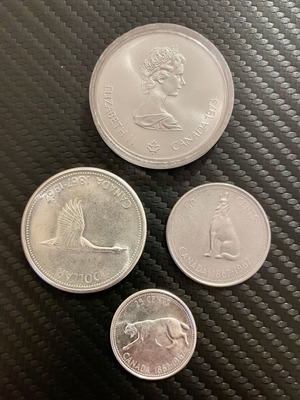 Silver coins like new with Elizabeth II portraits and North America map