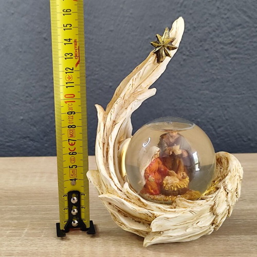 Christmas decorative snow globe featuring the Nativity and a base shaped like an angel's wing