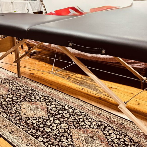 Portable folding massage bed with vinyl mattress, wooden frame