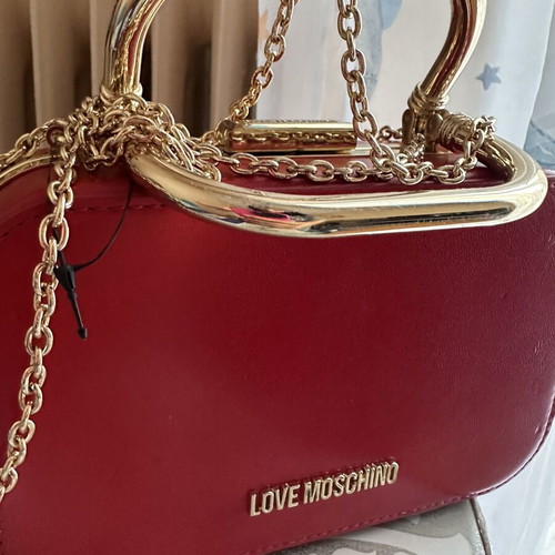 Love Moschino red shoulder bag like new with gold metal clasp and embossed detail