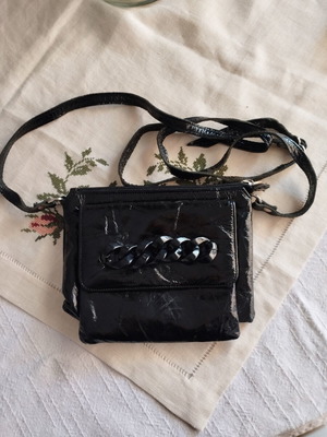 Black patent leather crossbody bag used with chain detail