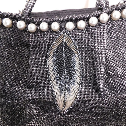 Handheld straw bag metallic like new with feather design and pearl accessory