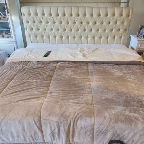 Double bed used with mattress and cream-colored headboard