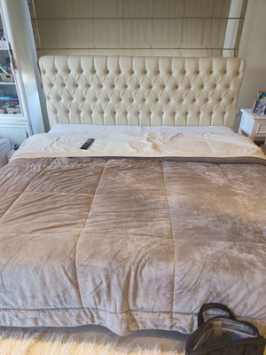 Double bed used with mattress and cream-colored headboard