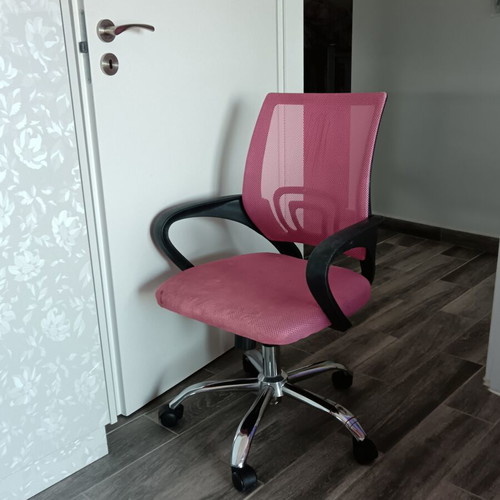 Office chair with armrests used, pink mesh fabric