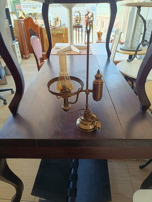 Retro table lamp made of brass used, oil lamp style with amber glass chimney