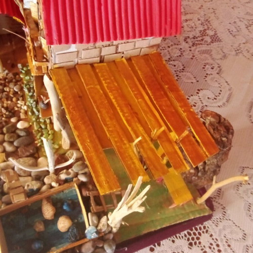 Handmade decorative house with cardboard, pebbles and driftwood, new