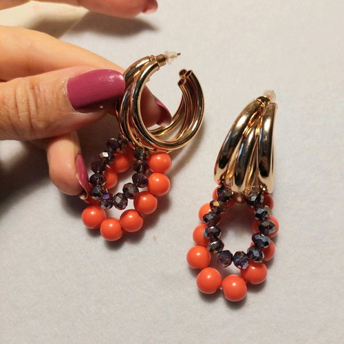 Handmade earrings with orange and purple beads on gold triple hoops