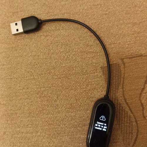 Mi Band smart watch used with charger, strap needs replacement