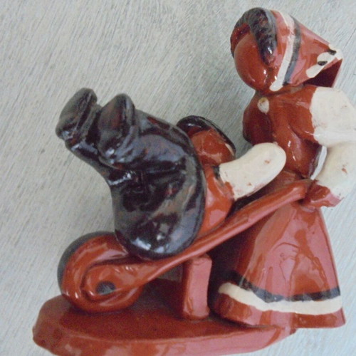 Ceramic figure used, retro genre scene woman pushing man in cart