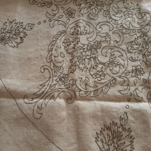 Stamped rosette with embroidered golden root on canvas