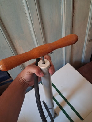 Manual air pump used with wooden handle and flexible hose