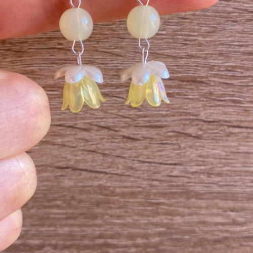 Handmade earrings with yellow and white beads and silver metal details