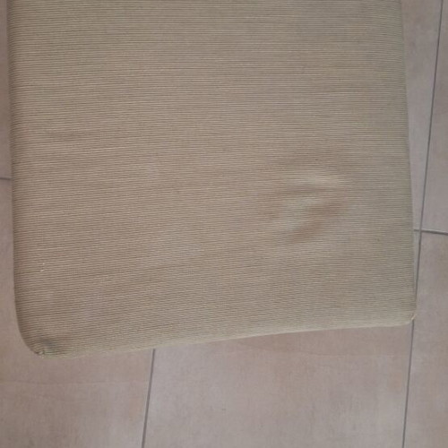 Light green fabric-covered stool with wooden legs
