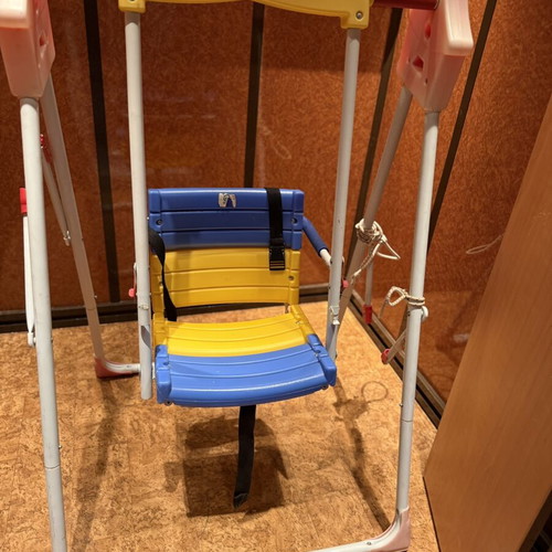 Children's swing with seat and safety straps used