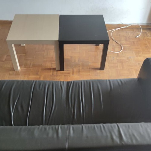 Black leather three-seater sofa used with coffee tables