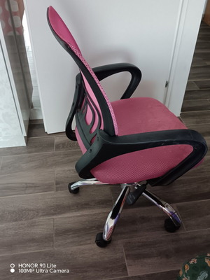 Office chair with armrests used, pink mesh fabric