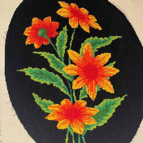 Handmade embroidery with orange daisies on black background used