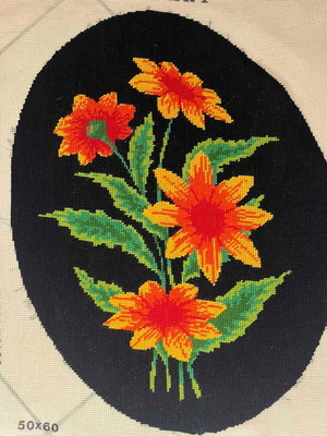 Handmade embroidery with orange daisies on black background used