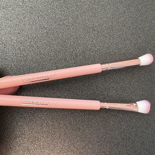 Gold makeup bag with two unused brushes