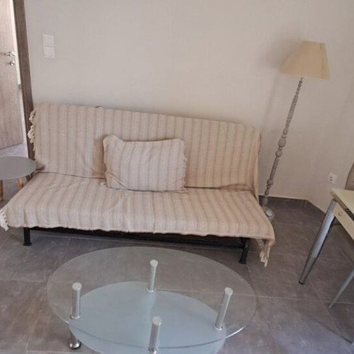 IKEA sofa bed, modern floor lamp, glass coffee table