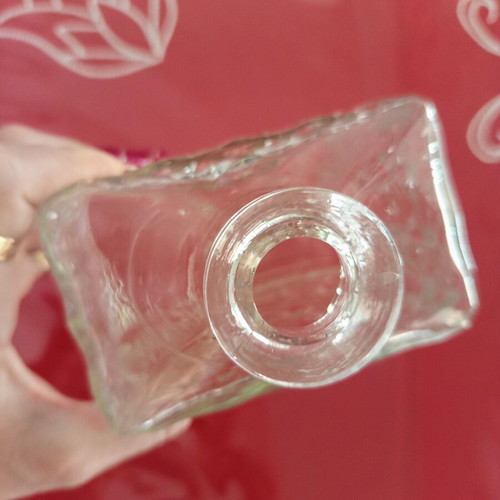 Vintage glass decanter with embossed geometric design and stopper