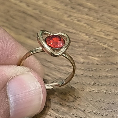 Gold-colored ring with heart and red stone, new