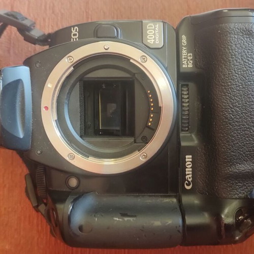 Canon EOS 400D camera used with grip, charger, and two batteries